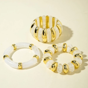 Close-up of white marble acrylic beaded bracelets with gold metal accents set of three