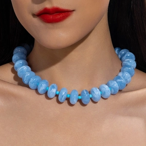 Detail shot of colorful acrylic beaded necklace with light blue marble texture on model
