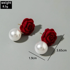 Detail view of red velvet rose and pearl earrings with specific size and weight dimensions