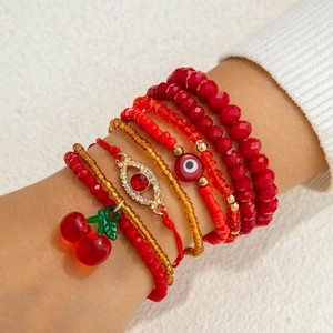 Bohemian multilayer red cherry beaded bracelet set with evil eye charms on woman's wrist