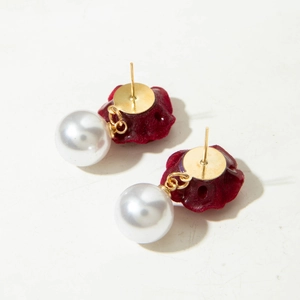 Detail of vintage red velvet flower earrings with large white pearl drops and gold studs