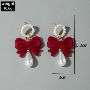 Detail view of red velvet bow earrings with pearls and dimensions 5.3cm by 3cm