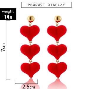 Detail view of red velvet triple heart drop earrings with dimensions 7cm by 2.5cm