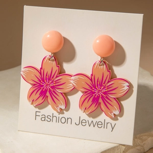Chic pink acrylic cherry blossom dangle earrings on a white jewelry display card