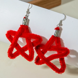 Detail view of red flocked star earrings with silver hooks on a clean white display stand