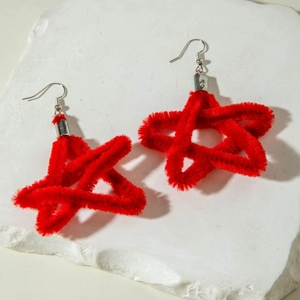 Detailed view of red plush star earrings on white stone display for Valentine's day