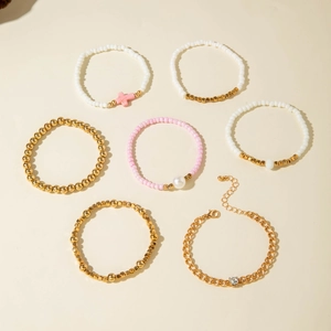 Set di sette braccialetti con perline dorate perle e ciondoli a forma di croce rosa