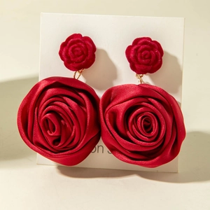 Detail of red silk rose earrings with velvet studs and layered satin flower petals