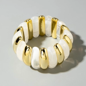 Detail of beaded acrylic curved tube bracelet with gold and white marble texture