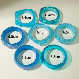 Detail of assorted blue translucent resin bangles with glitter and heart shapes