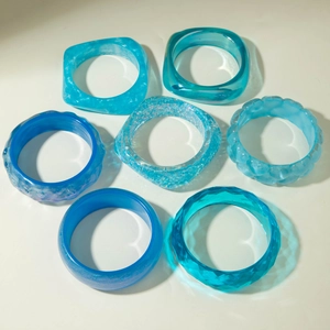 Macro detail of blue resin bracelets with glitter sequins and geometric facets