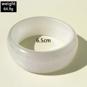 Gros plan d'un large bracelet en résine translucide avec détails de poids et diamètre