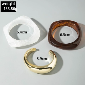 Three chunky bangles including marble resin and gold metal with inner diameter measurements