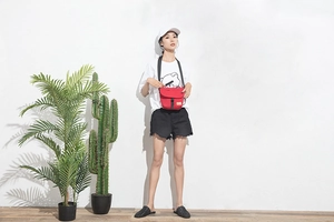 Rote große Nylon-Umhängetasche an einem Model in minimalistischer Innenumgebung
