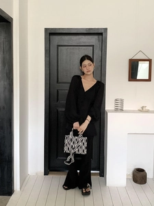 Détail d'un sac fourre-tout géométrique associé à une tenue noire élégante