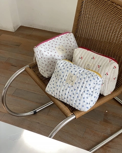 Detailed shot of quilted floral cosmetic bags with rabbit patches and zipper closures