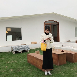 Photo en extérieur d'une femme portant un cabas en toile matelassée jaune vif et veste