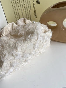Close-up of elegant lace handbag with 3D floral petals and delicate pearl accents