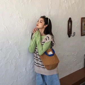 Détail d'un sac matelassé marron avec anses bleues et écusson animalier style japonais