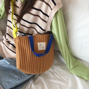 Détail du sac à bandoulière en coton matelassé jaune gingembre avec anses bleues