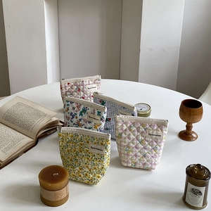 Détail de pochettes en coton matelassé aux motifs floraux et à carreaux