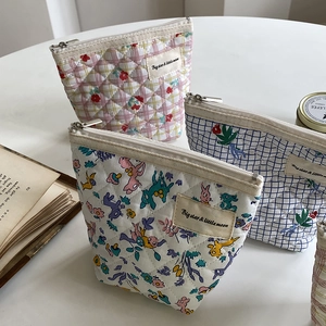 Vue détaillée de trousses de maquillage matelassées en coton avec motifs et fermeture