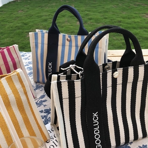 Détail des sacs fourre-tout en toile à rayures avec poignées imprimées en quatre couleurs