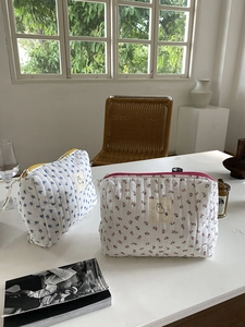 Detailed view of quilted cotton floral cosmetic bags with cute alpaca embroidery patches