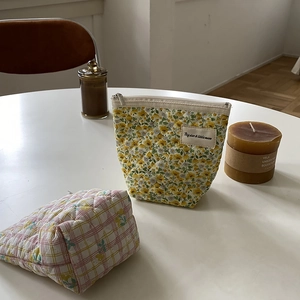 Détails de trousses à maquillage en coton matelassé aux motifs floraux et à carreaux