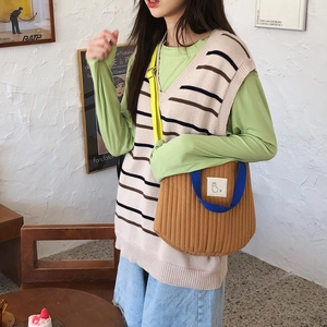 Détail d'un sac bandoulière en toile matelassée avec broderie chat et anses bleues