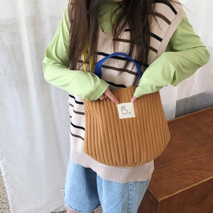 Gros plan du sac fourre-tout en toile matelassée marron avec des anses bleu marine