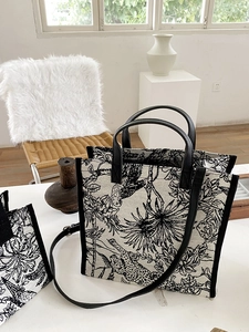 Détail du sac cabas en toile imprimé léopard avec bandoulière en cuir noir et métal