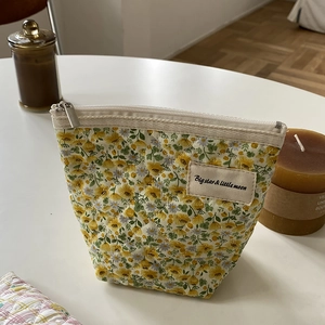 Gros plan d'une trousse à maquillage matelassée à fleurs avec fermeture éclair argentée