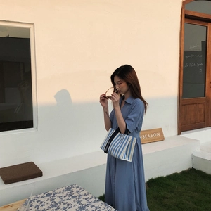 Détail d'un sac cabas en toile à rayures bleues et blanches avec bandoulière Goodluck brodée