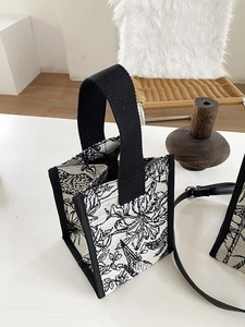 Détail du sac cabas en toile à motif floral avec broderie et poignée noire renforcée