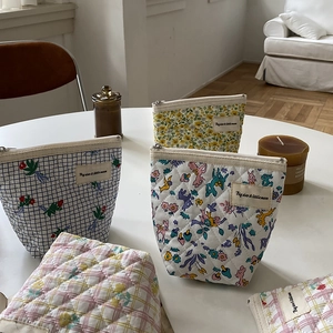 Détails de trousses à maquillage matelassées en coton avec motifs floraux et zip métal