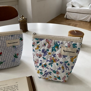 Détail de trousses de maquillage en coton matelassé avec motifs fleurs et animaux
