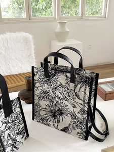 Détail du cabas en toile avec imprimés léopard et plantes tropicales et anses en cuir