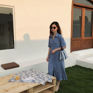 Photo en extérieur d'une robe bleue à manches courtes en coton et lin avec boutons et volants