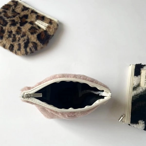 Three plush cosmetic bags featuring leopard print and pink faux fur with metal zippers