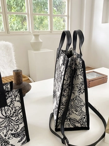 Détail d'un grand cabas en toile avec imprimé tropical tigre et finitions en cuir noir