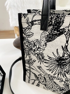 Détail du cabas en toile de Jouy avec motifs d'animaux et bordures en cuir noir