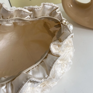Elegant cream lace vanity bag with pearl zipper and floral patterns for storage