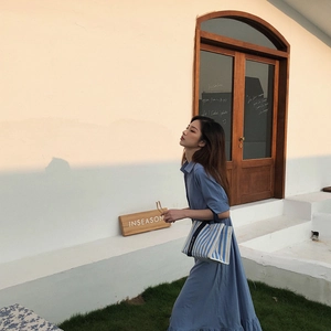 Détail du sac cabas en toile à rayures bleu et blanc avec texte Goodluck sur la bandoulière