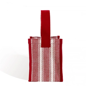 Minimalist red and white striped canvas handbag with red handles on white background