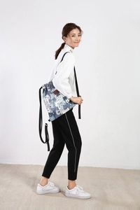 Verstellbare Kordelzugtasche mit Katzenmotiven, getragen von einem Modell vor neutralem Grund