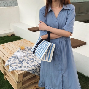 Détail d'une robe chemise bleu clair avec boutons et ourlet à volants élégants