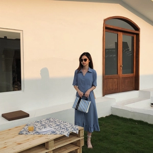 Gros plan d'un sac cabas en toile à rayures bleues et blanches porté par un modèle
