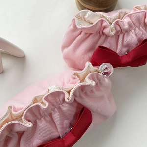 Detail of pink textured makeup bag with red bow and crystal zipper puller