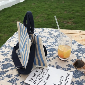 Sac fourre-tout en toile à rayures bleues et blanches sur une table de pique-nique
